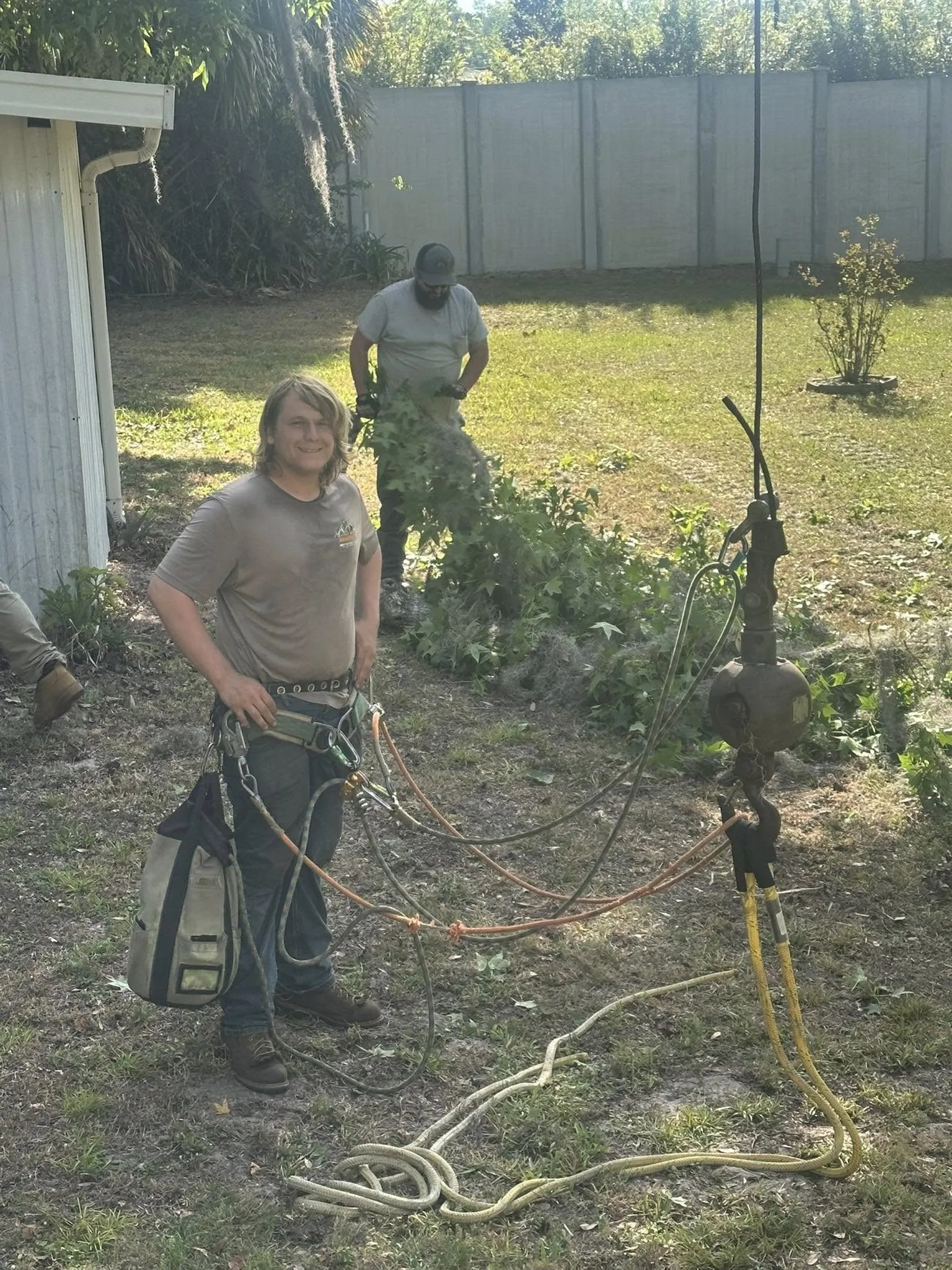 Smiling arborist in climbing gear ready to work